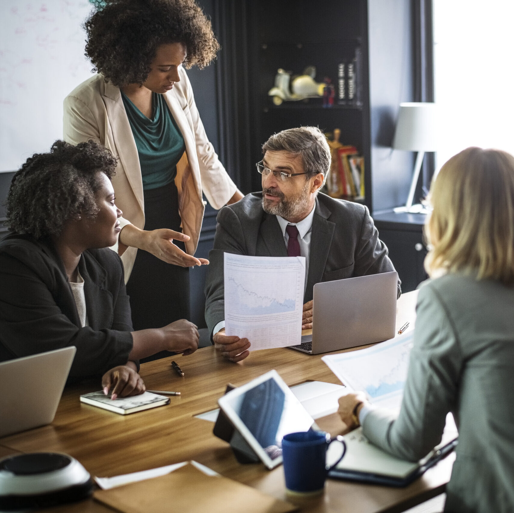 A diverse group of business professionals work at a conference table.